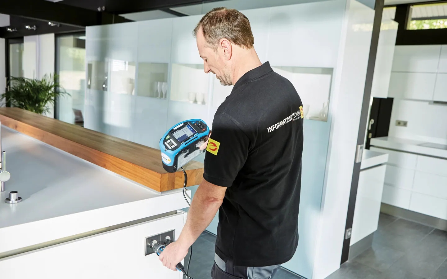 E-CHECK - Mitarbeiter prüft die Steckdosen in der Küche &middot; Elektro Hammes GmbH